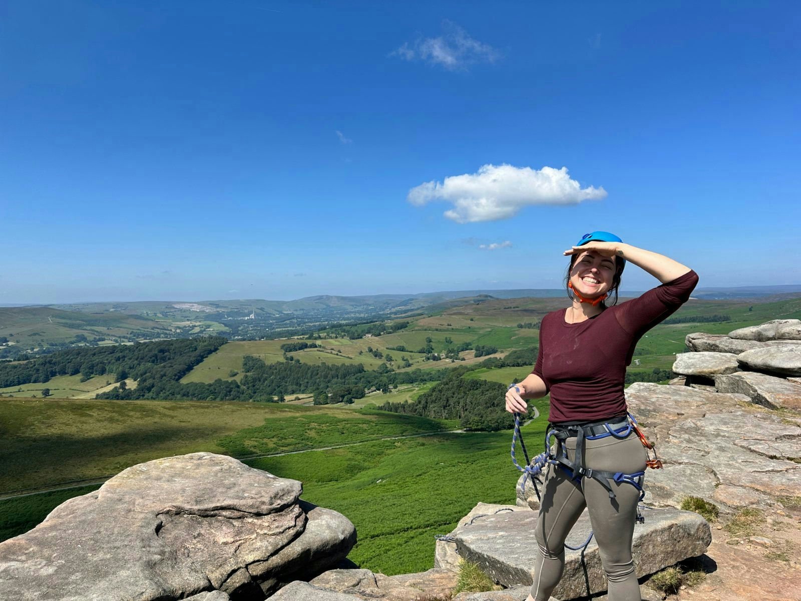 Climber on a gritstone edge looking out over the Hope Valley
