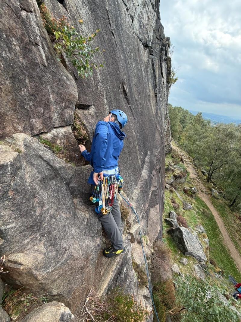 A climber with a trad rack on Peak District gritstone